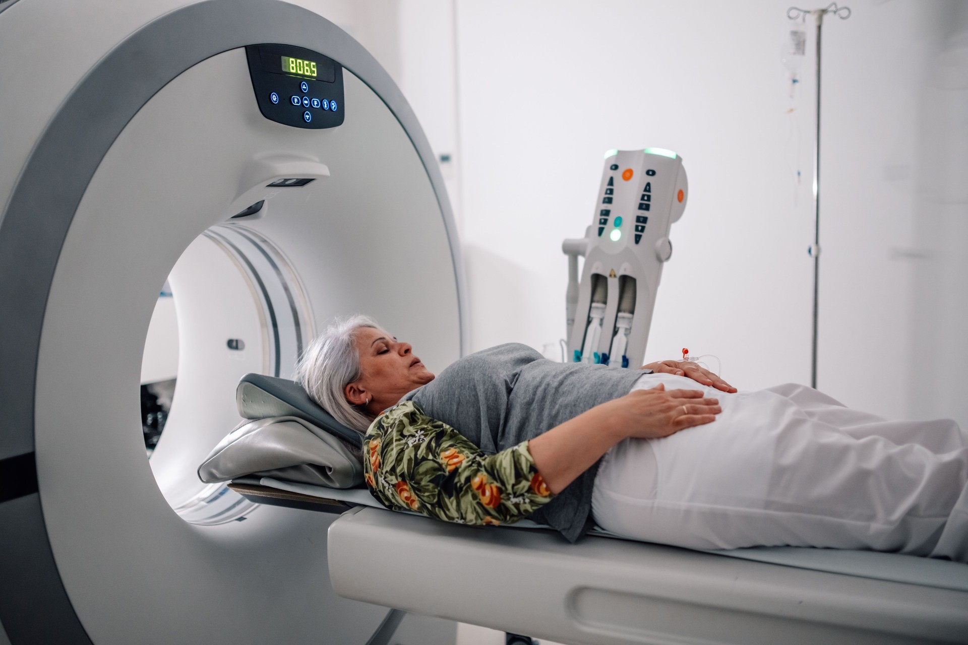 Radiology patient on CT scan machine bed in diagnostic center.